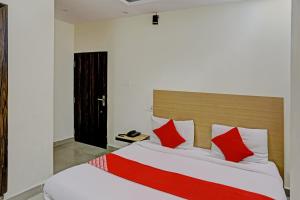 - une chambre avec un grand lit et des oreillers rouges dans l'établissement Hotel Dafodil, à Allahābād