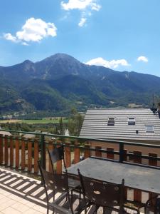 un tavolo su un balcone con vista sulle montagne di Gite les Myosotis a Saint-Jean-Saint-Nicolas