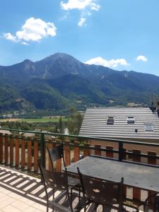 d'une table sur un balcon avec vue sur les montagnes. dans l'établissement Gite les Myosotis, à Saint-Jean-Saint-Nicolas