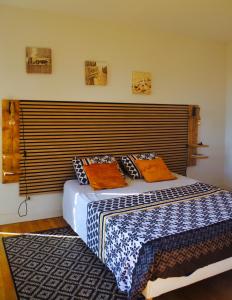 1 dormitorio con 1 cama con cabecero grande en Les Tanalis - Chambres d'hôtes & Gîte, en Gurs