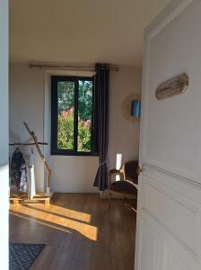 sala de estar con ventana y suelo de madera en Les Tanalis - Chambres d'hôtes & Gîte, en Gurs