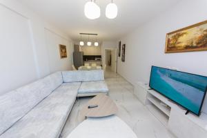 a living room with a large couch and a flat screen tv at Luxury Vila 3 in Vlorë