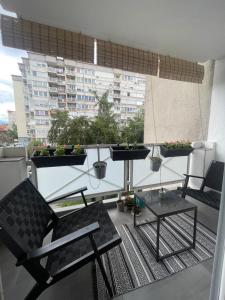 a balcony with two chairs and a table with plants at Golden Apartment With King Bed in Sarajevo