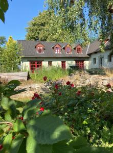 a house with red windows and a yard with flowers at Apartmány Penzion Kateřina in Nadějkov