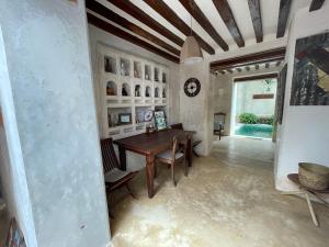 a dining room with a table and chairs and a ceiling at Authentic Swahili style villa Milele House in Lamu