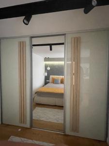 a bedroom with a bed through a sliding glass door at Golden Apartment With King Bed in Sarajevo