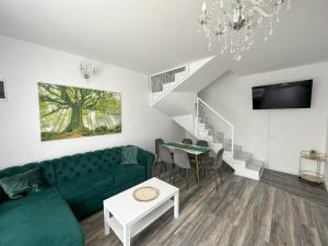 ein Wohnzimmer mit einem grünen Sofa und einem Tisch in der Unterkunft elisio - Maple House in Ghimbav