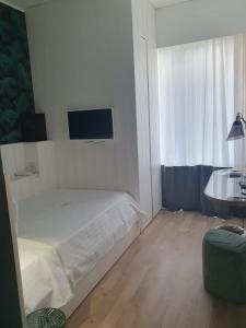 a bedroom with a bed and a tv on the wall at Hotel Ril in Lido di Jesolo