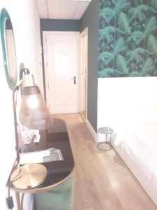 a bedroom with a table with a lamp and a bed at Hotel Ril in Lido di Jesolo