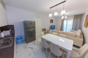 a kitchen and living room with a white table and chairs at Luxury Villa 4 in Vlorë
