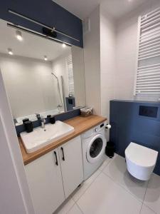 a bathroom with a sink and a washing machine at Niebieski Kwadrat - garaż podziemny + AC! in Rzeszów