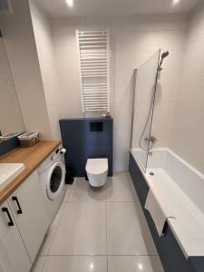 a bathroom with a toilet and a sink and a washing machine at Niebieski Kwadrat - garaż podziemny + AC! in Rzeszów +10 photos