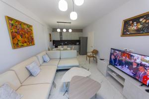 a living room with a couch and a flat screen tv at Luxury Villa 4 in Vlorë