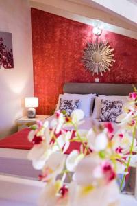 ein Schlafzimmer mit einem Bett mit einer roten Wand in der Unterkunft Rena’s house 2 in Argostoli