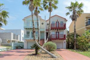 a house with palm trees in front of it at 3-level townhome w/ private pool & close to beach! in South Padre Island