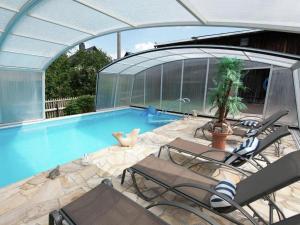 a swimming pool with chairs and a building with a tent at Ferienwohnung RiPa Erzgebirge in Schwarzenberg in Schwarzenberg