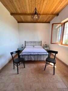 a bedroom with a bed and two chairs at Casa laggiù in Gradoli