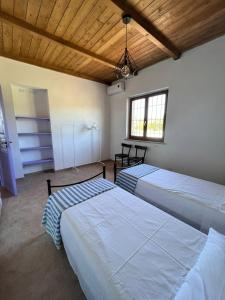two beds in a room with wooden ceilings at Casa laggiù in Gradoli