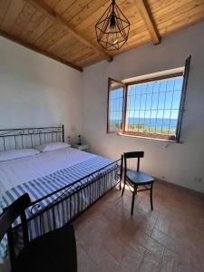 a bedroom with a bed and a chair and a window at Casa laggiù in Gradoli