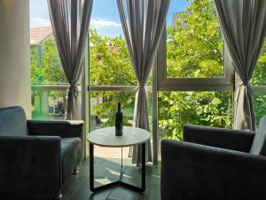 a room with two chairs and a table in front of a window at Lux Apartman Lazarević in Bajina Bašta