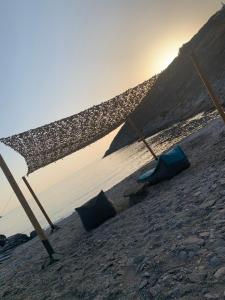 um grupo de guarda-sóis numa praia perto da água em Kythnos Beach house em Kythnos