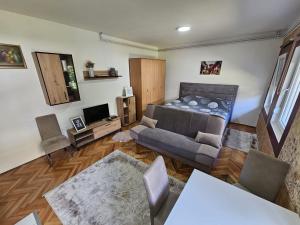 a living room with a bed and a couch at ALOHA apartment in Novi Pazar