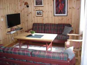 uma sala de estar com um sofá e uma mesa em Lemonsjø Fjellstue og Hyttegrend em Randsverk