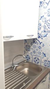 un lavandino in una cucina con piastrelle bianche e blu di Penisola Home Experience a Vico Equense