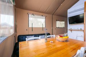 a dining room table with a bowl of fruit on it at Prima insula glamping in Brusići