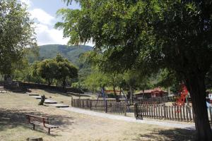 a park with a fence and a bench and a playground at Zeusplace Anastasia's Apartment 2 in Litochoro