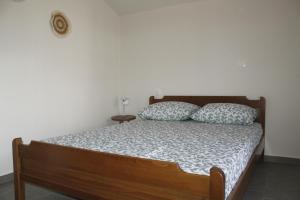 1 dormitorio con 1 cama de madera y 2 almohadas en Zeusplace Anastasia's Apartment 2, en Litóchoron