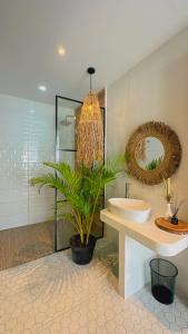 un bagno con lavandino e pianta in vaso di Demoska Villa Jogja With Privatepool a Kejayan