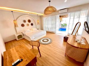 Demoska Villa Jogja With Privatepool في Kejayan: غرفة نوم بسرير وطاولة في غرفة