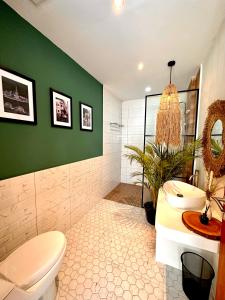 baño con aseo blanco y pared verde en Demoska Villa Jogja With Privatepool en Kejayan