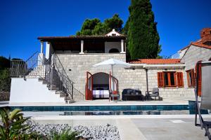 a villa with a swimming pool and a house at Vacation house Rubi in Dubrovnik