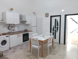 モルフェッタにあるNEW ROSE HOUSEの部屋にテーブルと椅子のあるキッチン