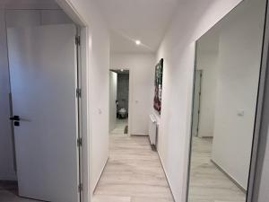 a hallway with white walls and a mirror at "Luxe Residence" Marsa avec Parking in Tunis