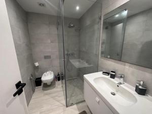 uma casa de banho com um chuveiro, um lavatório e um WC. em "Luxe Residence" Marsa avec Parking em Tunes