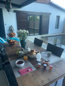 una mesa de madera con un plato de comida. en Villa Hermès Chambre bleue océan en San Pedro