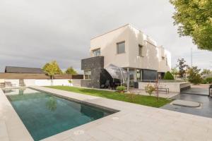 a house with a swimming pool in front of it at Oasis en Madrid con 4HB, 5 baños y Piscina Lujosa! in Villanueva del Pardillo