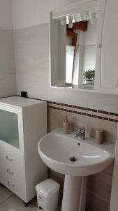 y baño con lavabo, espejo y aseo. en Chez Carlo, en Aosta