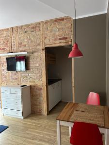 Habitación con mesa de comedor y pared de ladrillo. en Czesława, en Poznan