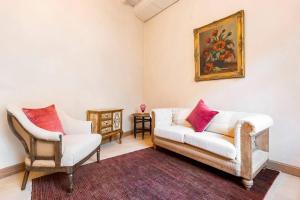 una sala de estar con 2 sillas y una pintura en la pared en Carriage House in quiet ecological garden en Amberes