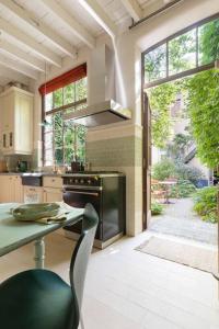 cocina con fogones, mesa y ventana en Carriage House in quiet ecological garden, en Amberes