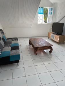 sala de estar con sofá y mesa de centro en ti sable appartement à 5 minutes de la mer en Saint-Joseph