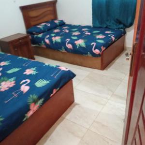 1 Schlafzimmer mit 2 Betten mit rosa Flamingos in der Unterkunft تيوليب فيلا in Madinat as-Sadis min Uktubar