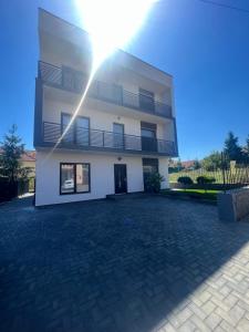 a large white building with a driveway at M&S Apartament 1 in Baile Felix