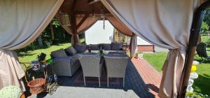 a patio with a table and chairs under a tent at Domek na wsi z Jacuzzi in Jedle