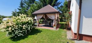 a gazebo with a table in a yard at Domek na wsi z Jacuzzi in Jedle +16 photos