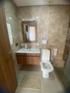 een badkamer met een toilet, een wastafel en een spiegel bij Élégant & Cosy Appartement in Casablanca